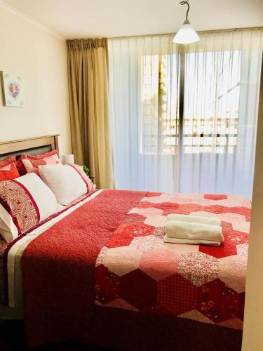 a red and white bed with two towels on it at Full Moneda 909 in Santiago