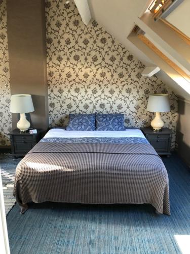 a bedroom with a large bed and two lamps at B&B Coupure in Bruges