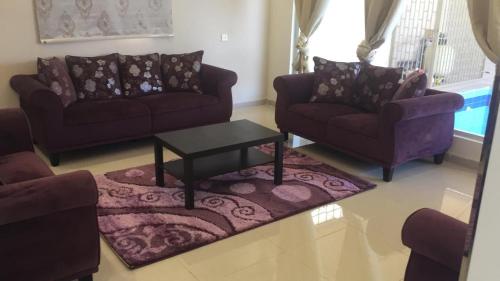 a living room with two couches and a coffee table at Al Taif Villas in Taif