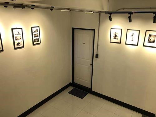 a room with a door and pictures on the wall at Backpack Hostel in Chiang Rai