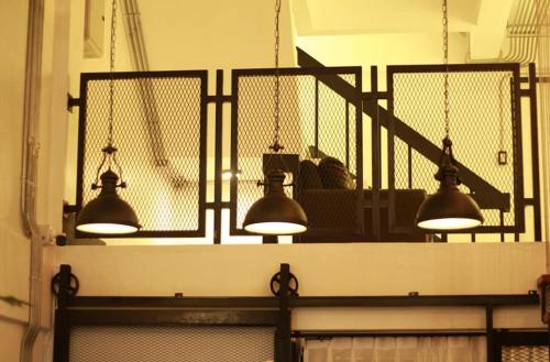 three lights hanging over a counter in a room at Backpack Hostel in Chiang Rai