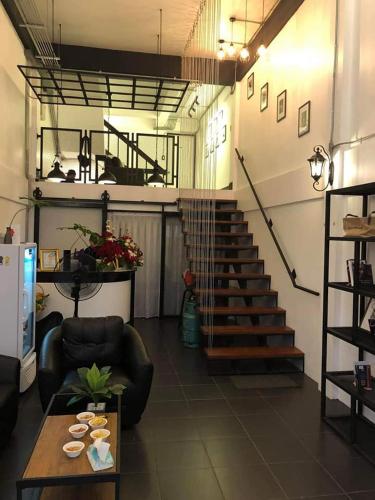 a living room with a staircase and a table at Backpack Hostel in Chiang Rai