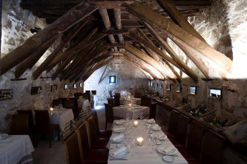a dining room with white tables and chairs in a building at Hotel Palacio de Mengibar in Mengibar