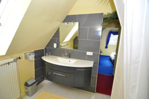 uma casa de banho com um lavatório e um espelho em Themen Hotel Terrassen Cafe em Bad Münder am Deister