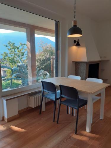 a dining room with a table and chairs and a window at Agriturismo Badalone in Domaso