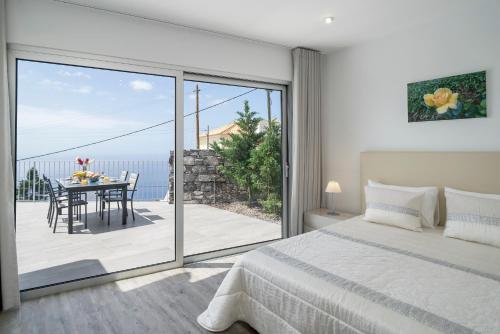 a bedroom with a bed and a table with chairs at OurMadeira - CalhetaScape, informal in Calheta