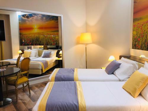 ein Hotelzimmer mit 2 Betten und einem Tisch in der Unterkunft AS Hotel Sempione Fiera in San Vittore Olona