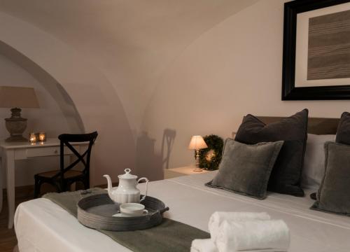 a bedroom with a white bed with a tea pot on it at Casa Teresinella in Torre Annunziata
