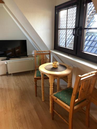 Habitación con mesa, 2 sillas y TV. en Ferienwohnung 2 Basthorst, en Basthorst