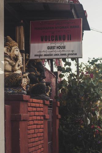a sign on the side of a building with a statue at Volcano Living in Kintamani