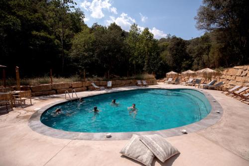 a group of people swimming in a swimming pool at Glamping Can Bora Lodges in Las Serras