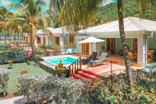 a house with a swimming pool in the yard at Bequia Beach Hotel - Luxury Resort in Friendship