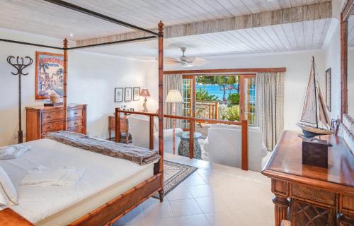 um quarto com uma cama de dossel e uma sala de estar em Bequia Beach Hotel - Luxury Resort em Friendship