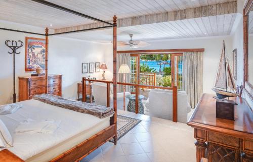a bedroom with a canopy bed and a living room at Bequia Beach Hotel - Luxury Resort in Friendship