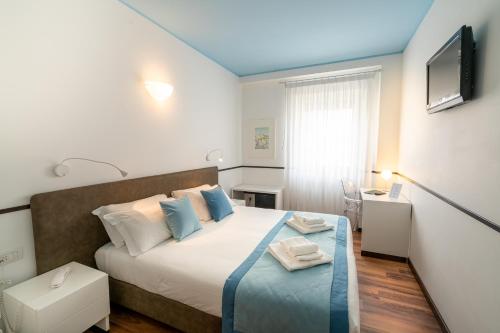 a bedroom with a large bed with blue pillows at Covo dei Saraceni in Polignano a Mare