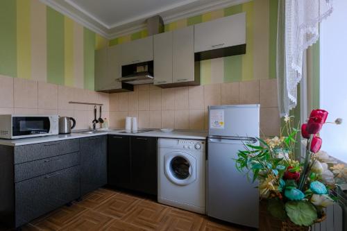 a kitchen with a washing machine and a microwave at Apart Petrovskie on Sovetskaya 60 in Tomsk