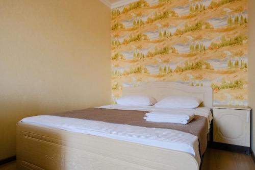 a bedroom with a bed with a painting on the wall at Apart Petrovskie on Sovetskaya 60 in Tomsk