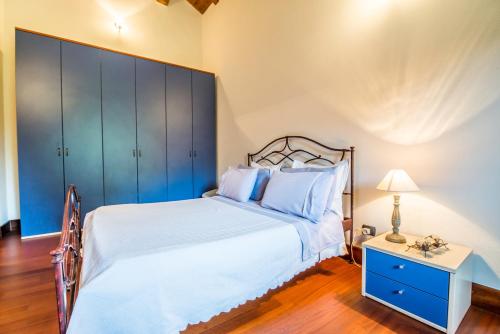 a bedroom with a large bed and a blue cabinet at B&b Antica Dimora Quarello in Orbassano
