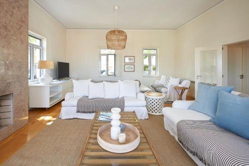 a living room with white furniture and a fireplace at Saboia -Spacious Gorgeous Apartment in Monte Estoril