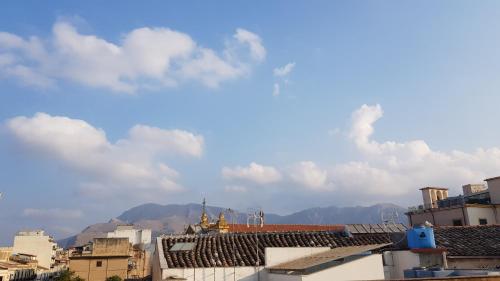 a view of roofs of buildings with mountains in the background at Al Baglio di Maqueda in Palermo