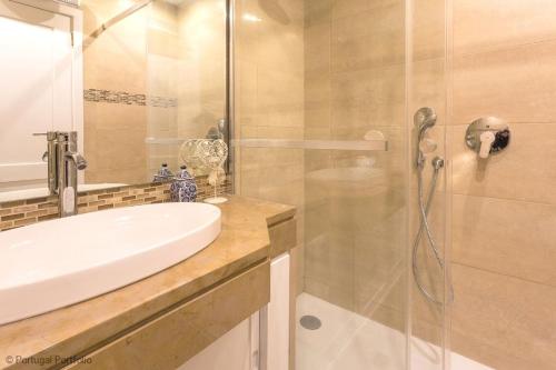 bagno con lavandino e doccia in vetro di Cascais Panoramic Apartment a Cascais