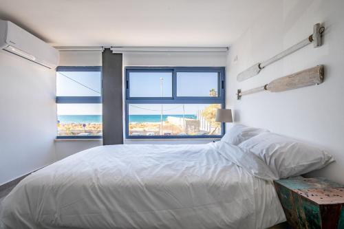 1 dormitorio con cama y ventana con vistas al océano en PORT CITY HAIFA - BAT GALIM oceanfront luxury en Haifa