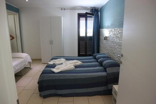 1 dormitorio con 1 cama con toallas en torquemada beach club, en Margherita di Savoia