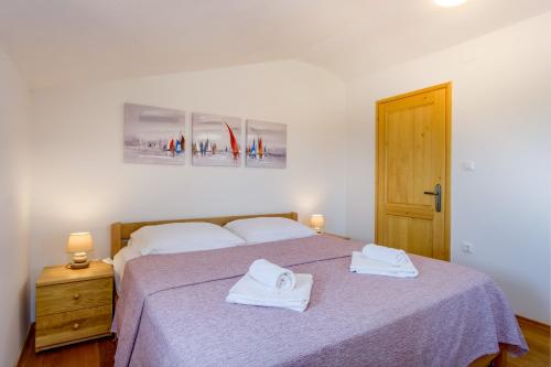 a bedroom with a bed with two towels on it at Holiday home Verin in Mali Lošinj
