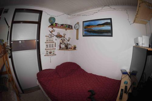 Un pequeño dormitorio con una cama roja en una habitación en Casa Bohinj en Bohinj