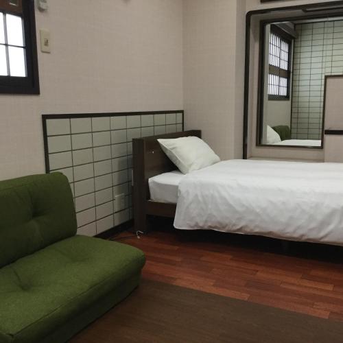 a bedroom with two beds and a chair and a mirror at HOTEL Ra KAGOSHIMA in Kagoshima