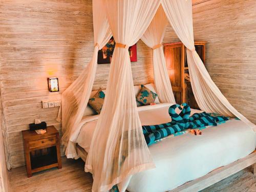 - une chambre avec un lit à baldaquin dans l'établissement The Lucky Cottage, à Nusa Lembongan