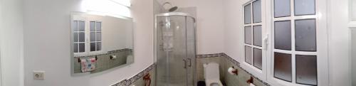 een badkamer met een douche, een toilet en een raam bij Apartamento para familias in Marzagán