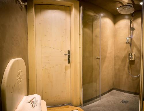 a bathroom with a shower and a glass door at Hotel & Spa Le Dahu in Morzine