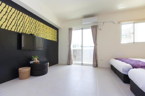 a bedroom with two beds and a flat screen tv at Fun Homestay in Jian