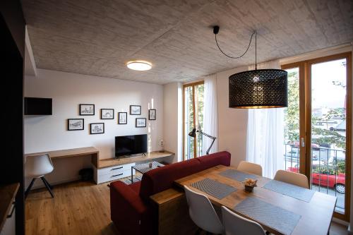 uma sala de estar com uma mesa e um sofá em Postcard City Apartments em Maribor