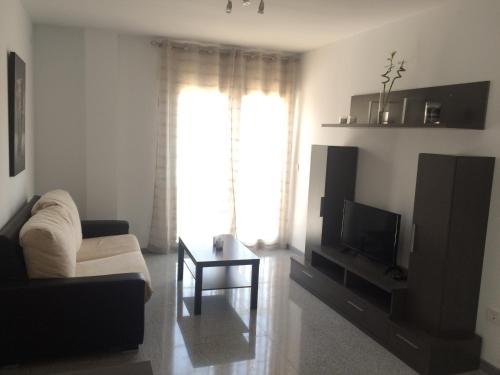 - un salon avec un canapé et une télévision dans l'établissement Apartamento de una habitación, à Malaga