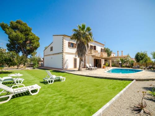 a villa with a lawn and a swimming pool at Holiday Home Casa Sanso by Interhome in Cala Anguila