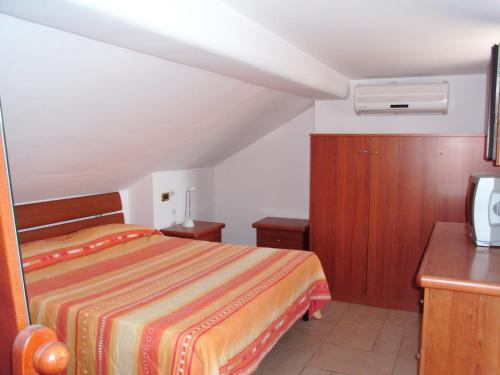 a bedroom with a bed and a desk and a tv at Villino Rosalia in Sperlonga
