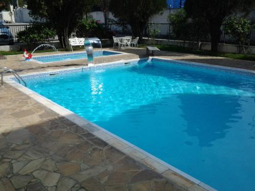 a large swimming pool with blue water at Blanco Palace Hotel in São José dos Campos