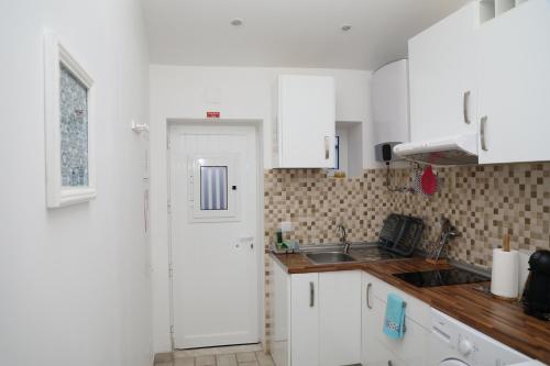 a kitchen with white cabinets and a sink at Manta Rota Holiday Home in Manta Rota