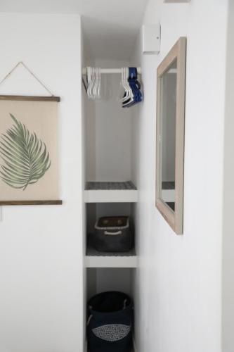 a bathroom with white walls and a mirror at Manta Rota Holiday Home in Manta Rota