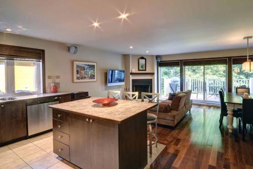 a kitchen and living room with a table and a couch at Borealis by Rendez-Vous Mont-Tremblant in Mont-Tremblant