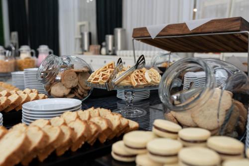 a buffet of food with pies and pastries on a table at Ker San Telmo Hotel in Buenos Aires