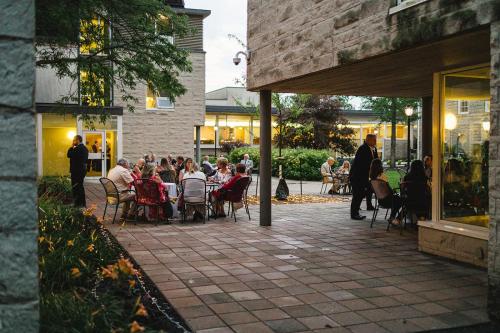 un grupo de personas sentadas en mesas en un patio en Donald Gordon Hotel and Conference Centre en Kingston