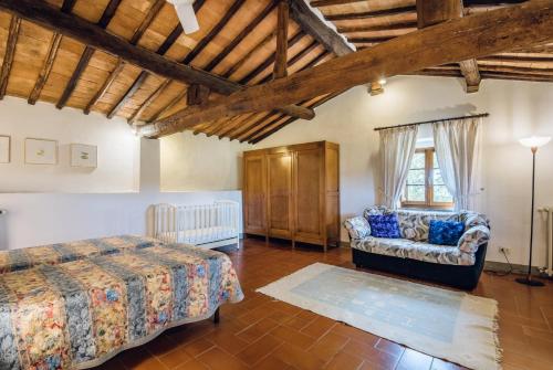 a bedroom with a bed and a couch in a room at Agriturismo La Ferrozzola in Castellina in Chianti