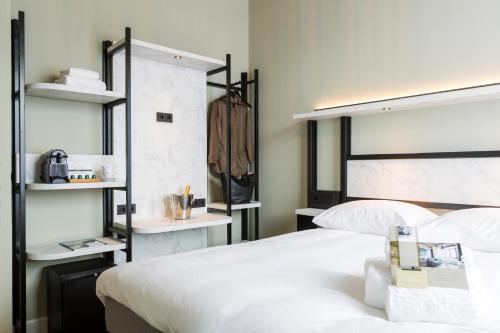 a hotel room with a bed and a dresser at Boutique Hotel Lumiere in Eindhoven