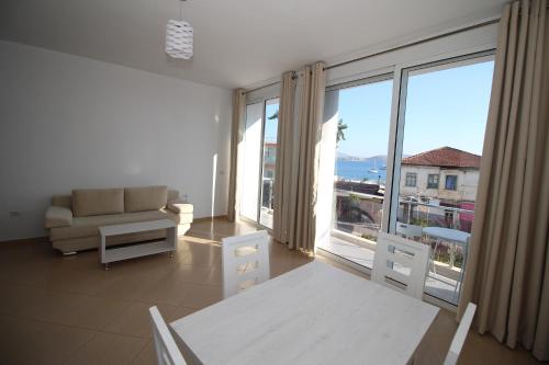 a living room with a couch and a large window at Kristina Hotel in Sarandë