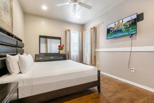 1 dormitorio con 1 cama y TV en la pared en Spacious 3BR/2.5BATH Condo in Great location, en Nueva Orleans
