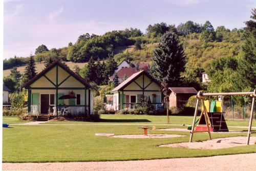 a playground in front of a house at Village-Chalets Le Rû du Pré in Cravant