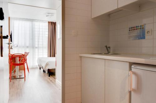 
a kitchen with a sink and a refrigerator at Residhotel Galerie Tatry in Bordeaux
